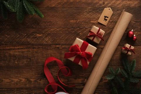 Gift wrapping items, roll of brown kraft paper, red velvet ribbon, labels o.. Stock Photos