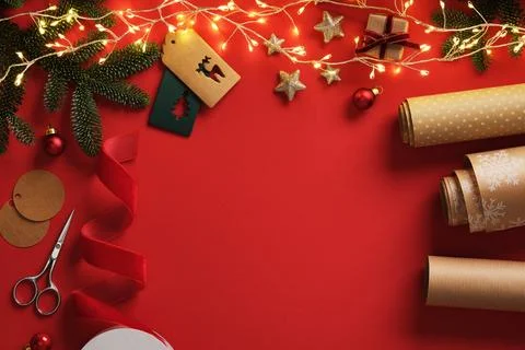 Gift wrapping items, roll of brown kraft paper, red velvet ribbon, labels on  Stock Photos