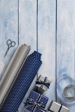 Gift wrapping items. Rolls of wrapping paper, scissors, ribbon, ready-wrapp.. Stock Photos