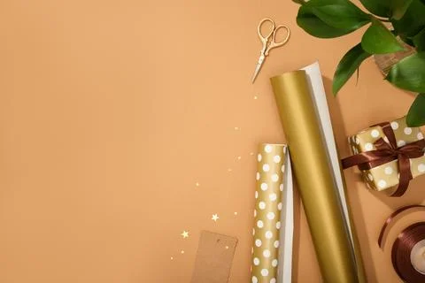 Gift wrapping materials. Rolls of wrapping paper, ribbon, gift. Brown backgro 库存照片