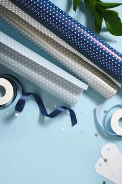 Gift wrapping materials. Rolls of wrapping paper, ribbon, gift. Blue backgrou Stock Photos