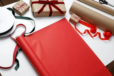 Gift wrapping paper spread on table prepared for present packaging process Stock Photos