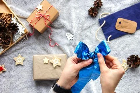 Gift wrapping process. Blue bow. Gifts in craft paper. Festive atmosphere Stock Photos