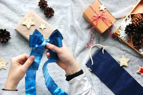 Gift wrapping process. Blue bow. Gifts in craft paper. Festive atmosphere Foto stock