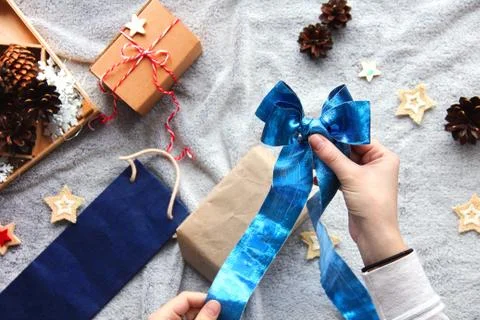 Gift wrapping process. Blue bow. Gifts in craft paper. Festive atmosphere Foto stock