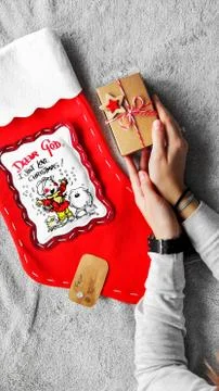 Gift wrapping process. Red Christmas sock Gifts in craft paper.  Stock Photos