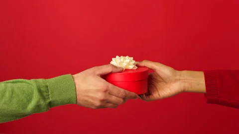 Gift you will admire. Close up of hands of girl giving a gift with ribbon to her Stock Footage 146127078