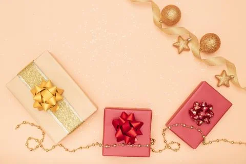 Gifts boxes or presents boxes with red and golden bows, star and ball on gold Stock Photos