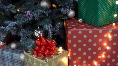 Gifts in bright boxes with a bow under a Christmas tree in 4K. Stock Footage 130875310