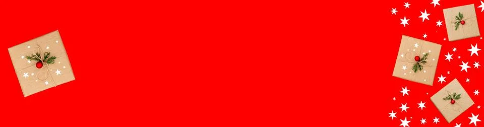 Gifts in craft packaging on a red background, banner Stock Photos
