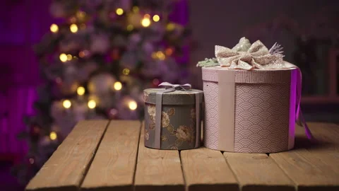 Gifts in round boxes against background of Christmas tree on New Year's Eve Stock Footage 165167838