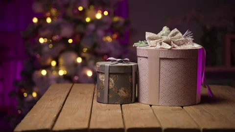 Gifts in round boxes against background of Christmas tree on New Year's Eve Stock Footage 165698074