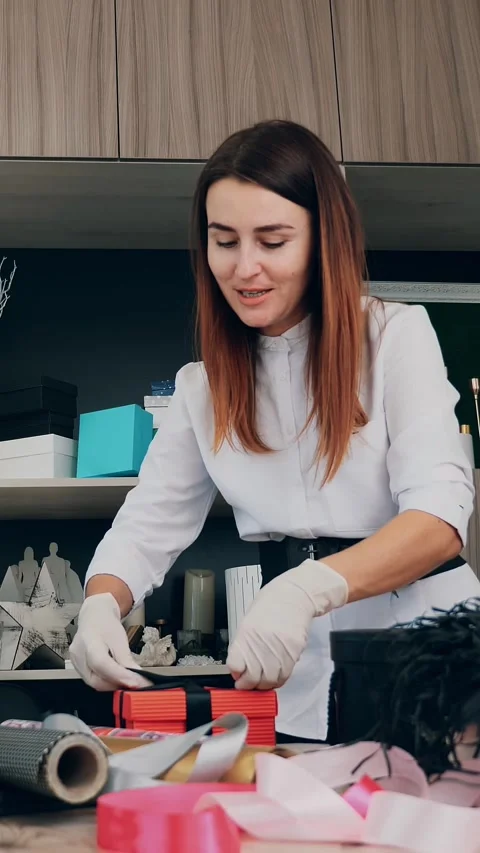 Gifts wrapping close-up. Designer, in protective gloves, decorates, packs a gift Stock Footage 316985691