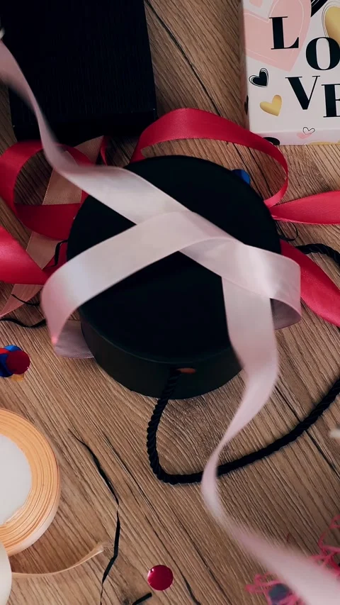 Gifts wrapping close-up. Top view on table with gift box and colorful ribbons. Stock Footage 323289396