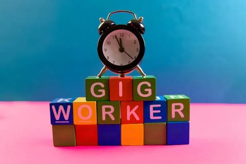 Gig worker concept with alarm clock and colorful blocks Stock Photos