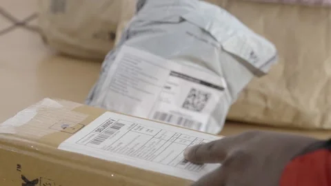 Gig worker scanning QR code of a parcel at warehouse Stock Footage 327393174