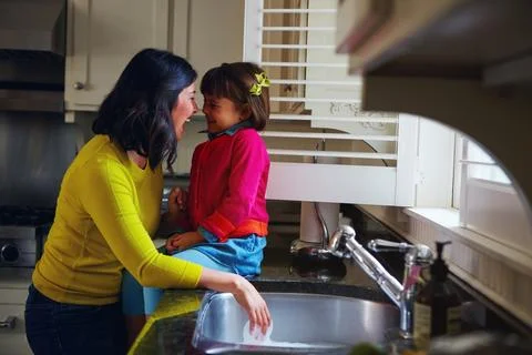 Giggles in the kitchen. a young mother and her daughter bonding by the kitchen Stock Photos