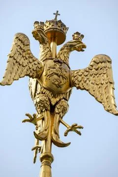 A gilded double-headed eagle statue crowned and perched atop a pole. Stock Photos