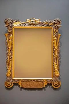 Gilded rectangular wooden frame on a gray background. Mockup for your text Stock Photos