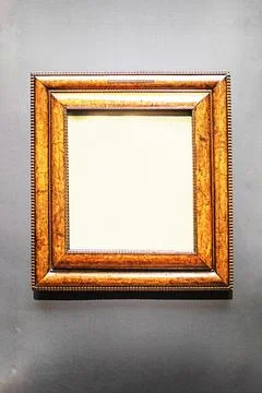 Gilded rectangular wooden frame on a gray background. Mockup for your text Stock Photos