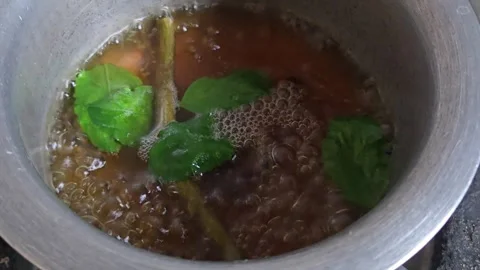 This giloy stem, tulsi, and black pepper kadha boils on a hot stove flame. Sweet Vídeos de archivo 340993743