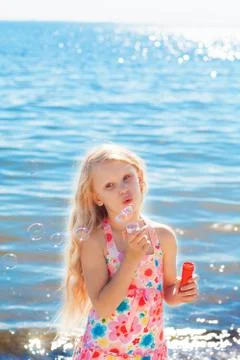 Gilrl with soap bubbles on the seashore Stock Photos