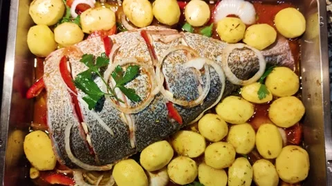 Gilt head bream fish prepared for the oven with potatoes and vegetables Stock Footage 230177075