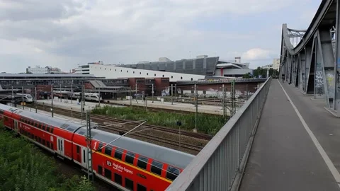 Gimbal shot of red train moving under hacker bridge. Stock Footage 169140093