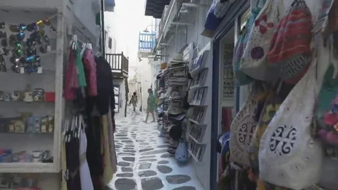 Gimbal shot walking down a narrow mykonos alley past shops Stock Footage 69278747
