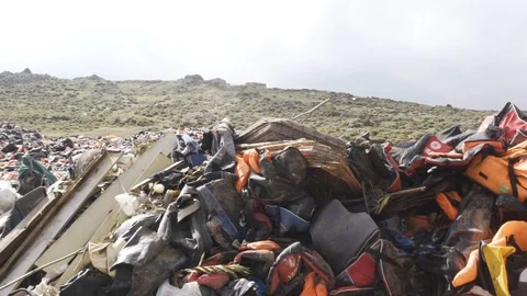 Gimbal slow motion left to right refugee lifejacket dump in Lesbos in 2019 Video stock 116441702