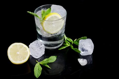 Gin and tonic with ice cubes and slice of lemon. Stock Photos