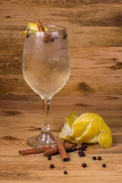 Gin tonic with lemon slice, cinnamon sticks and juniper. At thewood backgroun Stock Photos