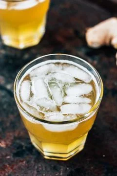 Ginger ale on black rustic surface with ice. Stock Photos