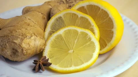 Ginger and sliced lemon rotating on a round white plate. Prores 4K. Stock Footage 66702019