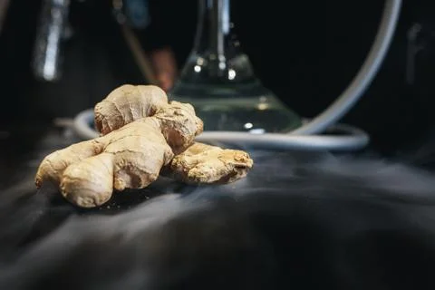 Ginger on black background. In the background are hookah and smoke. Stock Photos