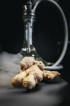 Ginger on black background. In the background are hookah and smoke. Stock Photos