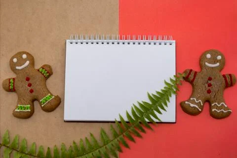 Ginger bread cookies on red background . Blank notepad with leaf of fern. Coffee Stock Photos
