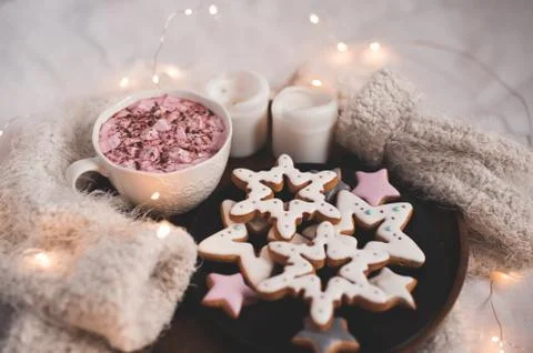 Ginger breads in star shape with coffee cup ovr glowing lights on knitted swe Stock Photos