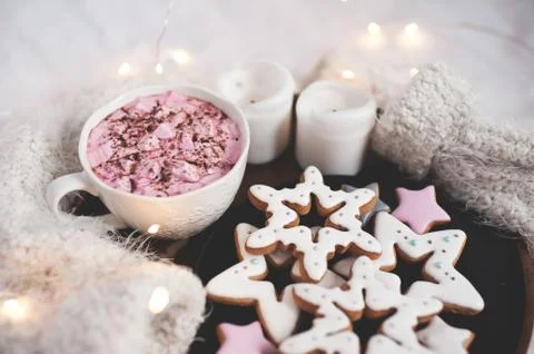 Ginger breads in star shape with coffee cup ovr glowing lights on knitted swe Stock Photos