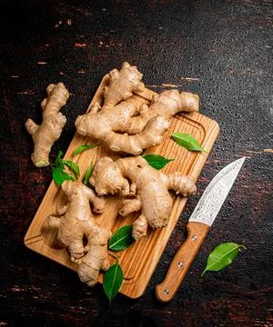 Ginger on a cutting board with a knife. Fotos de archivo