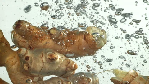 Ginger falling underwater on a white background. Filmed on a high-speed camera Stock Footage 322808586