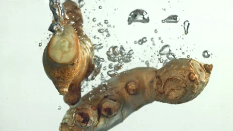 Ginger falling underwater on a white background. Filmed on a high-speed camera Stock Footage 322881312