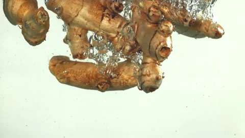Ginger falling underwater on a white background. Filmed on a high-speed camera Stock Footage 322894214