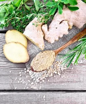Ginger ground in spoon with root on board top Stock Photos