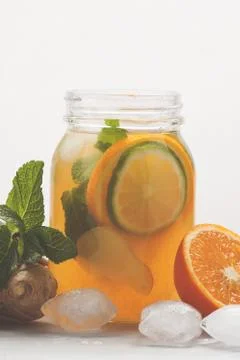 Ginger orange ice tea with mint in a glass jar, white background, copy space. Stock-Fotos