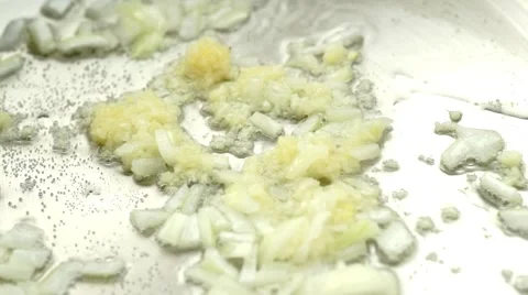 Ginger paste added to wok with hot oil, onion and minced garlic being stir fr Stock Footage 68936541