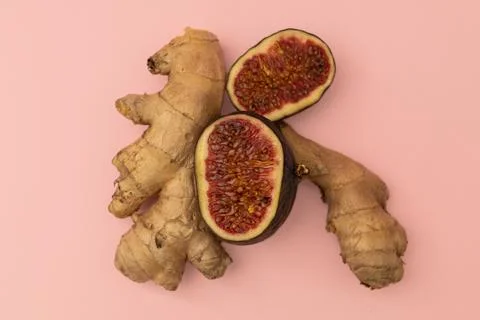 Ginger root and cut figs on a pink background Stock Photos