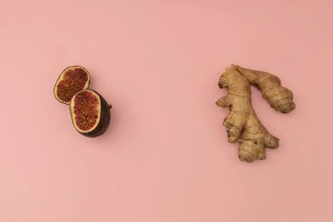Ginger root and cut figs on a pink background Stock Photos