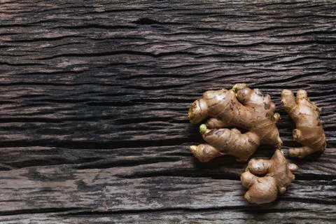 Ginger root and ginger. Fresh ginger root on the wooden table with copy space Stock Photos