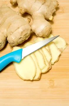 Ginger root on a bamboo chopping block Stock Photos